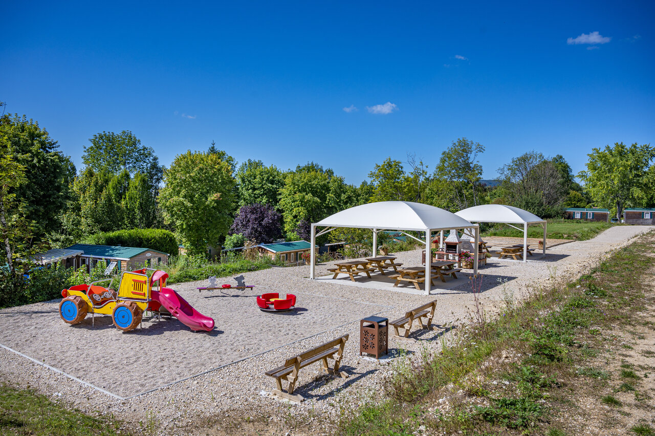 Aire de jeux color�e, toboggan et tables de pique-nique au camping CAPFUN Pergola � Marigny (39).