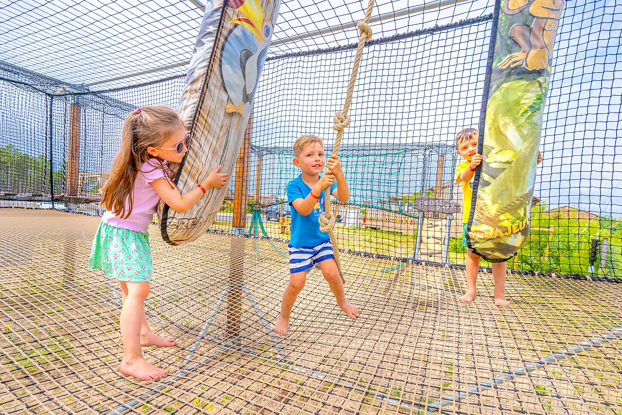 Enfants s'amusant sur un parcours de jeux en filet au camping CLICOCHIC Petit Nice � PYLA SUR MER (33).