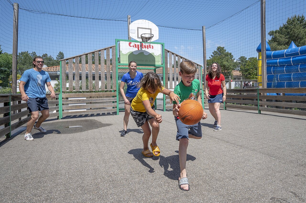 Terrain multisport avec enfants jouant au basketball au camping CAPFUN Pin�da � CAZAUX (33).