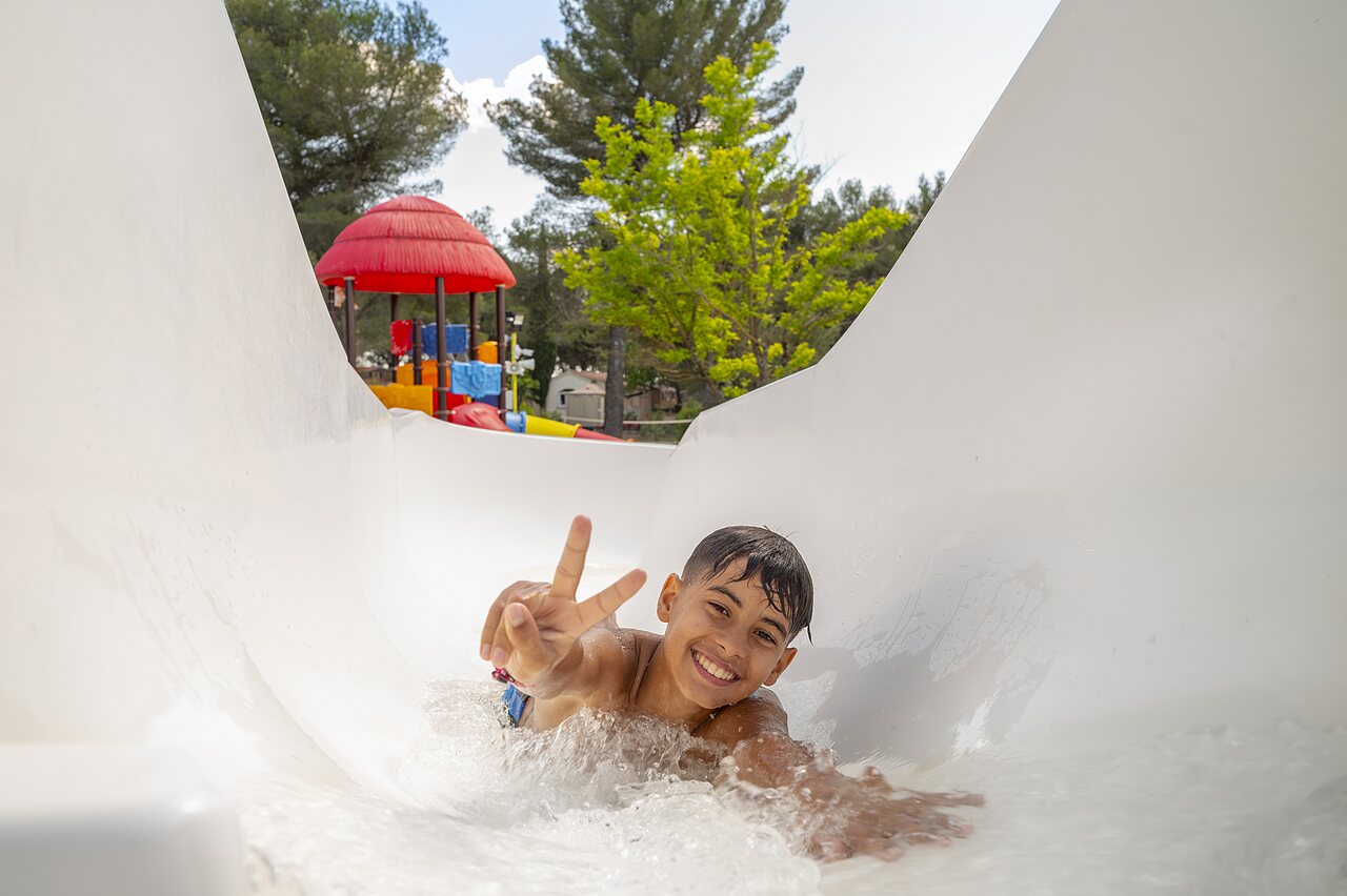 Enfant souriant sur toboggan aquatique au camping CAPFUN Pin�des du Luberon � PERTUIS (84).
