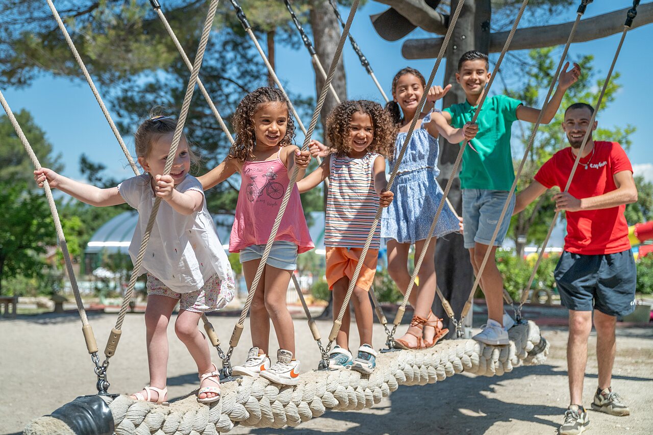 Enfants et animateur sur pont de cordes, aire de jeux au camping CAPFUN Pin�des du Luberon � PERTUIS (84).