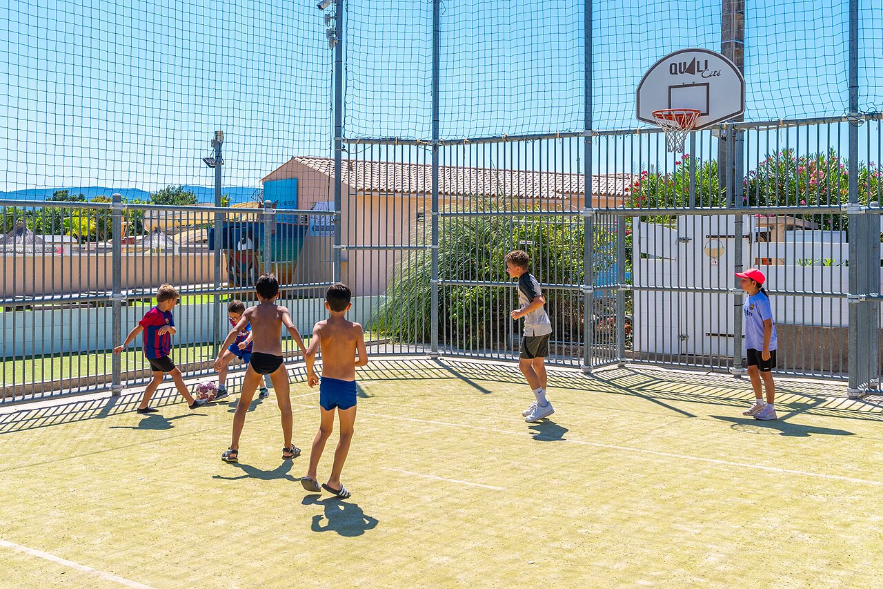 Enfants jouant au football sur terrain multisport au CAPFUN La Pin�de de Grimaud (83).