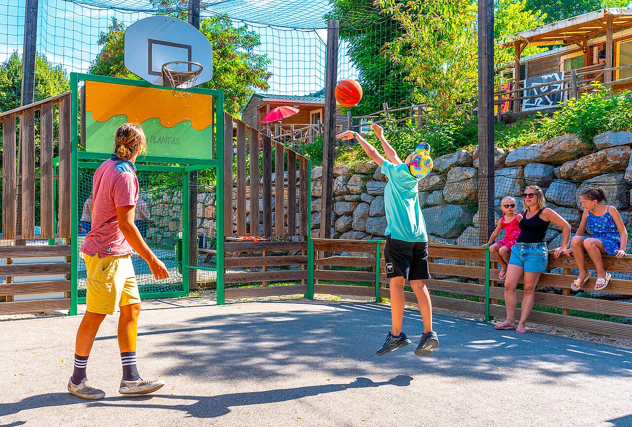 Terrain multisport avec jeunes jouant au basketball au camping CAPFUN Plantas � SAINT VINCENT DE DURFORT (07).