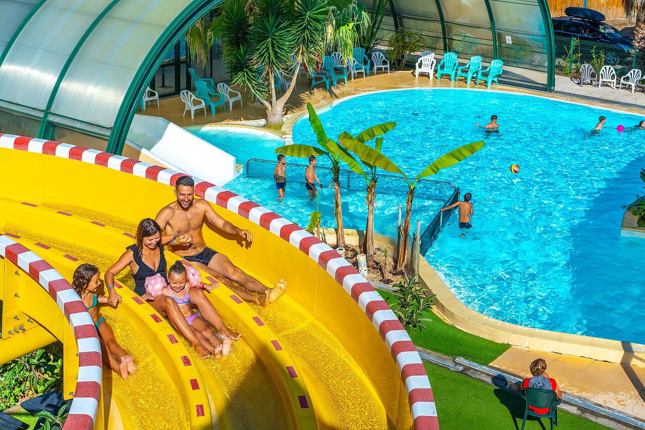 Famille sur toboggan aquatique et piscine au camping CAPFUN Pomme de Pin � Saubion.