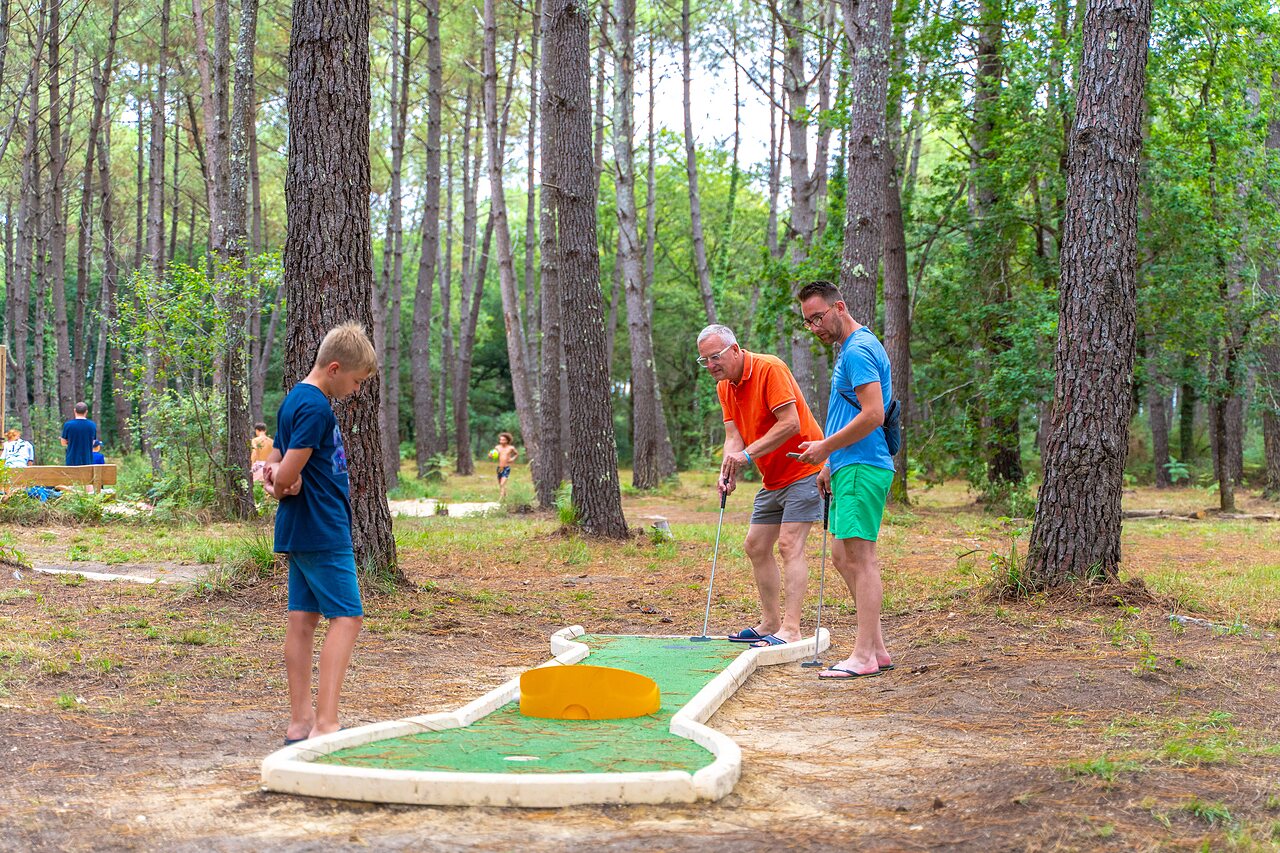Famille jouant au mini-golf en for�t au camping CAPFUN Pomme de Pin � Saubion (40).