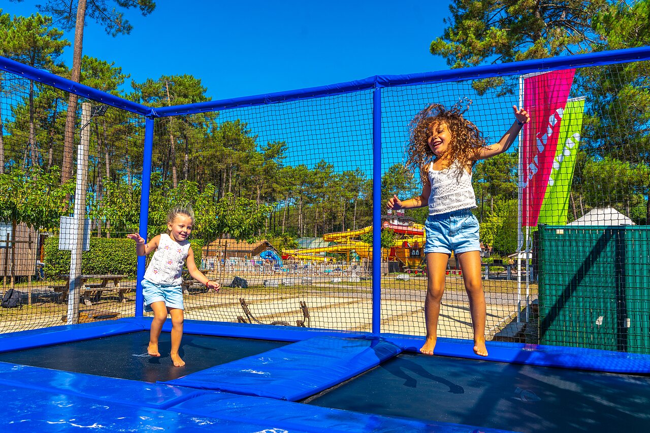Deux enfants joyeux sautant sur trampolines au camping CAPFUN Pomme de Pin � Saubion (40).