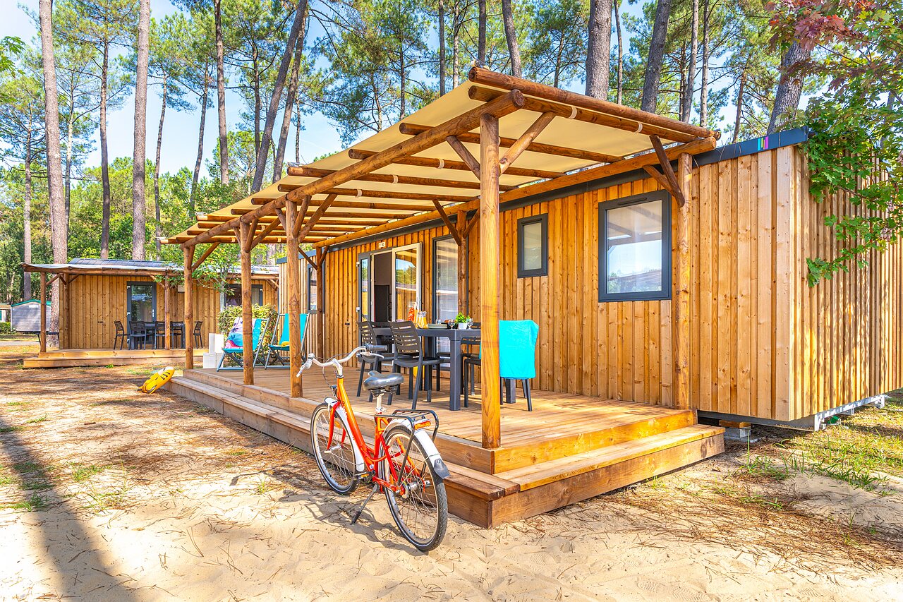 Mobile-home en bois avec terrasse couverte et v�lo, au camping CAPFUN Pomme de Pin � Saubion (40).
