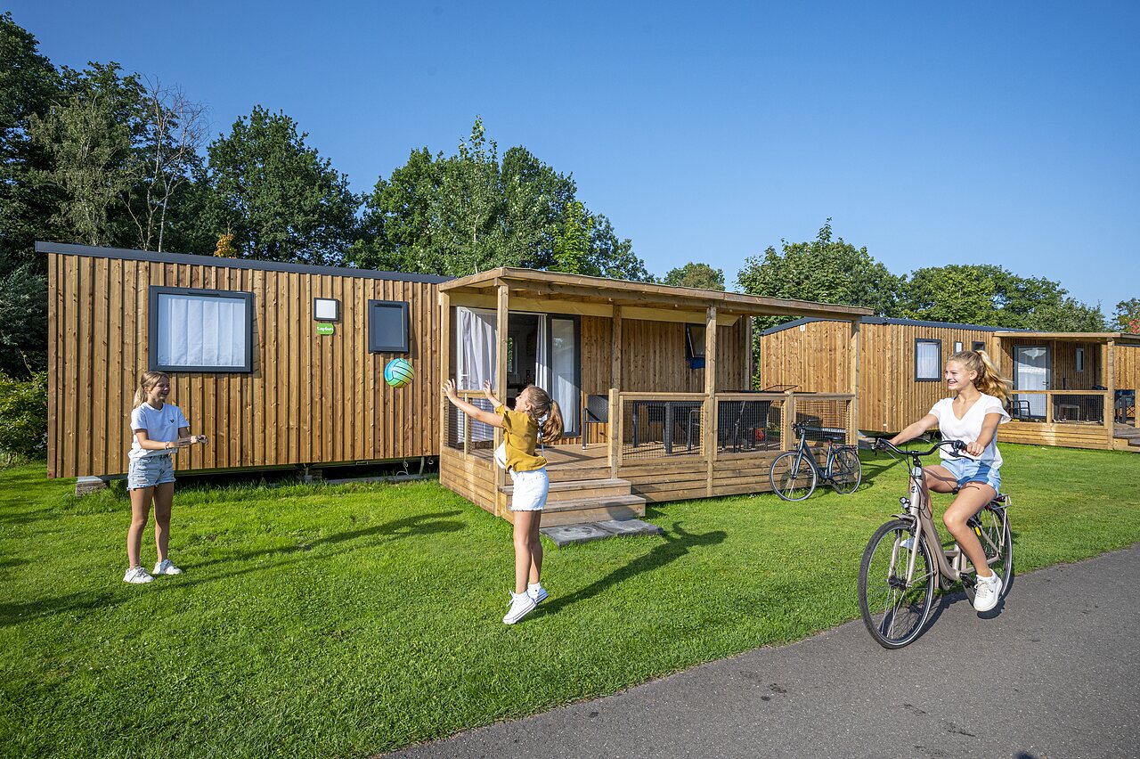 Mobil-homes en bois, enfants jouant et � v�lo au camping CAPFUN Ponderosa � Ulicoten.