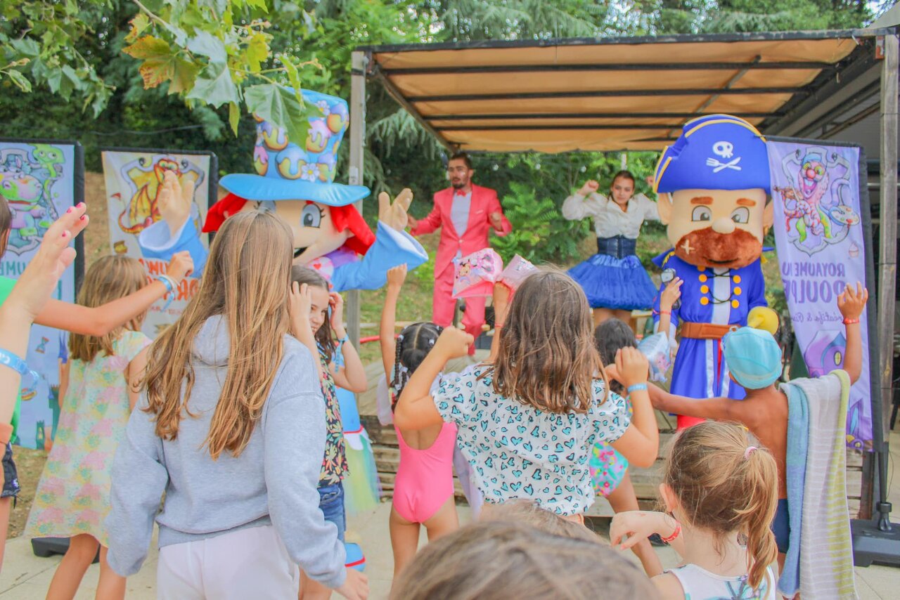 Enfants dansant avec mascottes et animateurs sur sc�ne au camping CAPFUN Les Portes du Beaujolais � Anse (69).