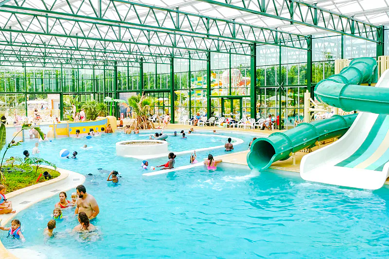 Indoor pool, waterslides, play area at VAGUES OCEANES campsite Near La Fontaine in Gouaix (77).