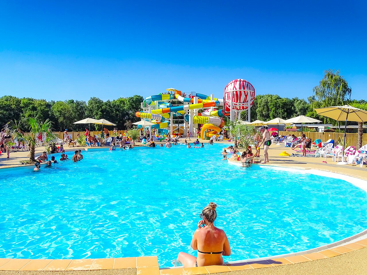 Large outdoor pool with water slides and games at VAGUES OCEANES campsite near Gouaix (77).