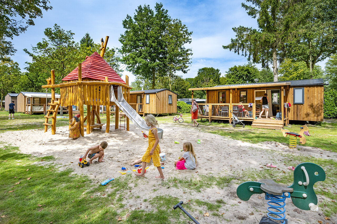 Aire de jeux avec toboggan, enfants et Mobil-homes au camping CAPFUN Rakelbos � Westelbeers.