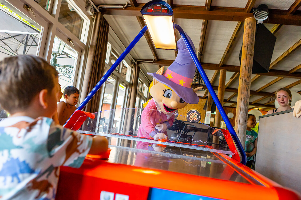Mascotte et enfants jouant � l'air hockey au camping CAPFUN Rakelbos � Westelbeers.