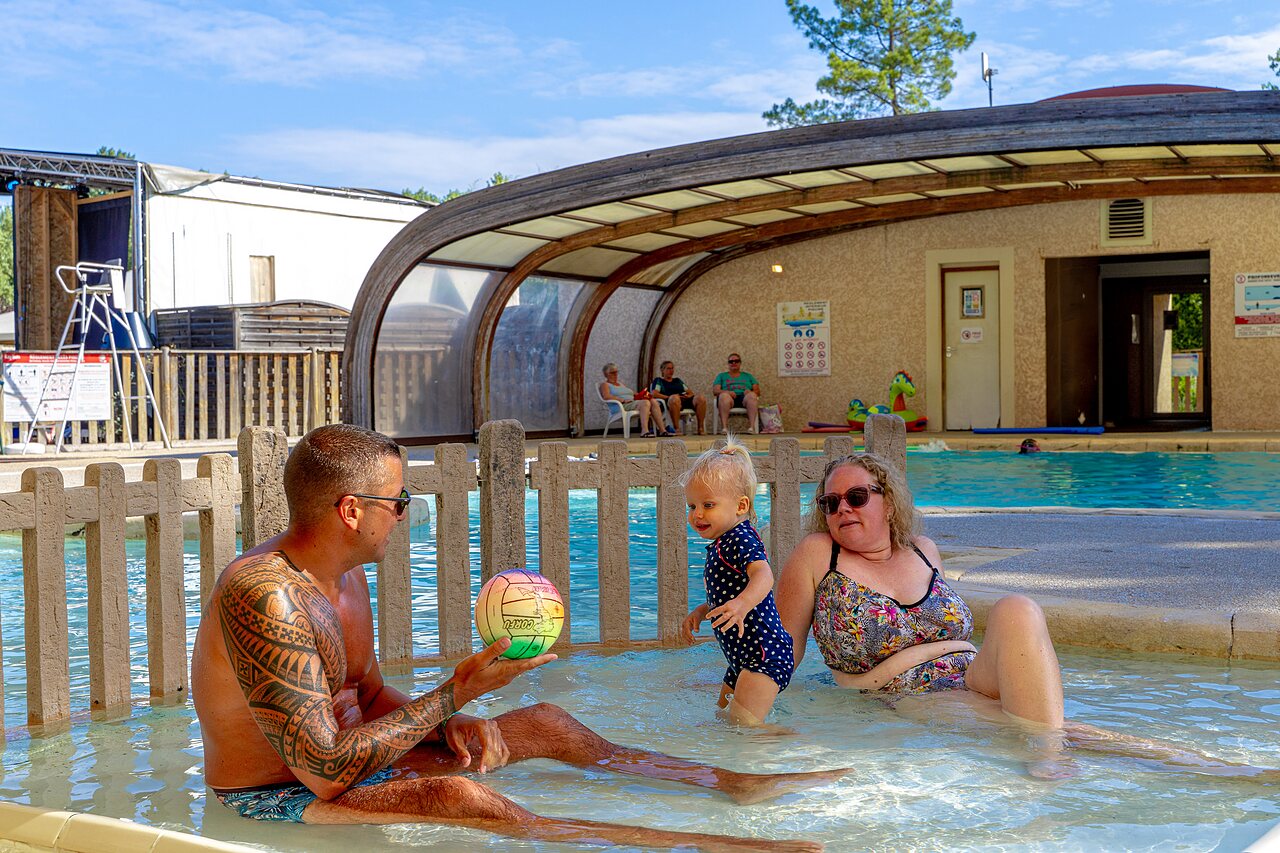 Famille avec b�b� dans la pataugeoire, piscine couverte au camping CAPFUN R�gni�re � VILLETTE D'ANTHON (38).