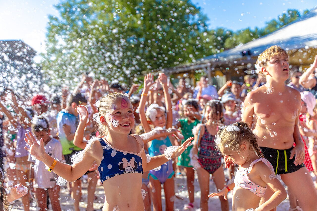 Enfants joyeux participant � une f�te mousse anim�e au camping CAPFUN R�gni�re � VILLETTE D'ANTHON (38).
