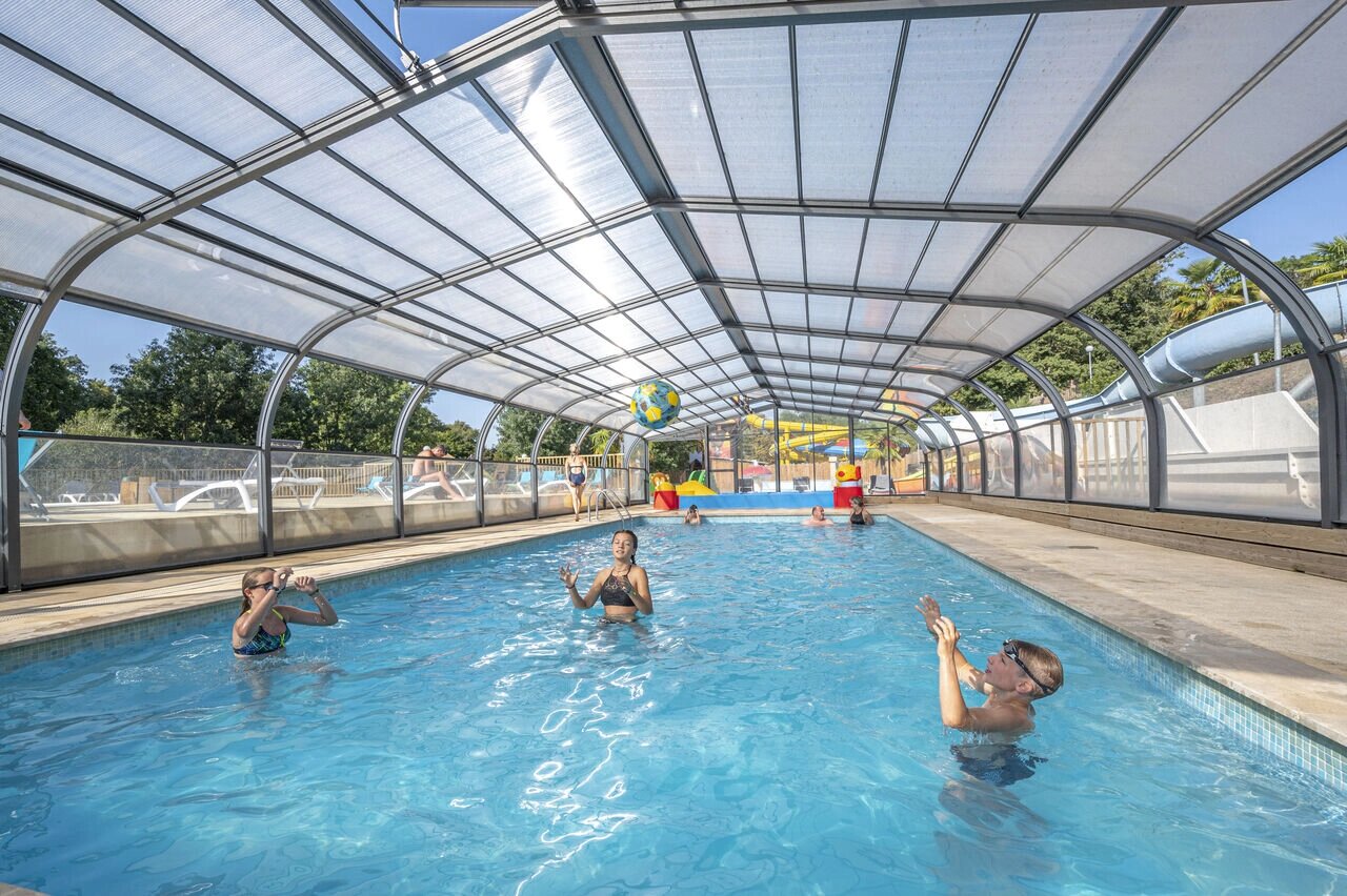 Piscine couverte, enfants jouant, toboggans au camping CAPFUN La Rivi�re � Valence-en-Poitou (86).