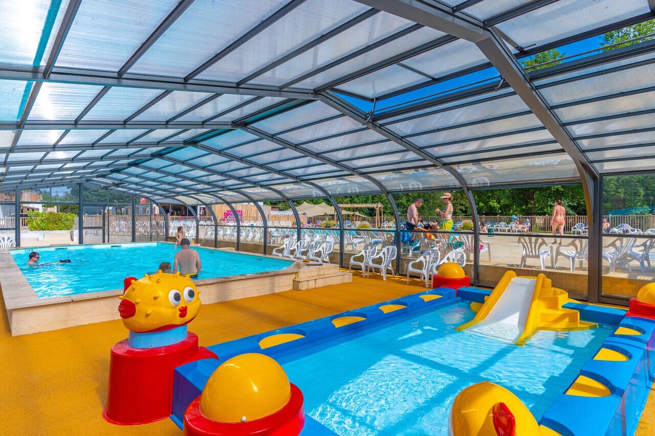 Piscine couverte avec toboggan et pataugeoire enfants au camping CAPFUN La Rivi�re � Valence-en-Poitou (86).