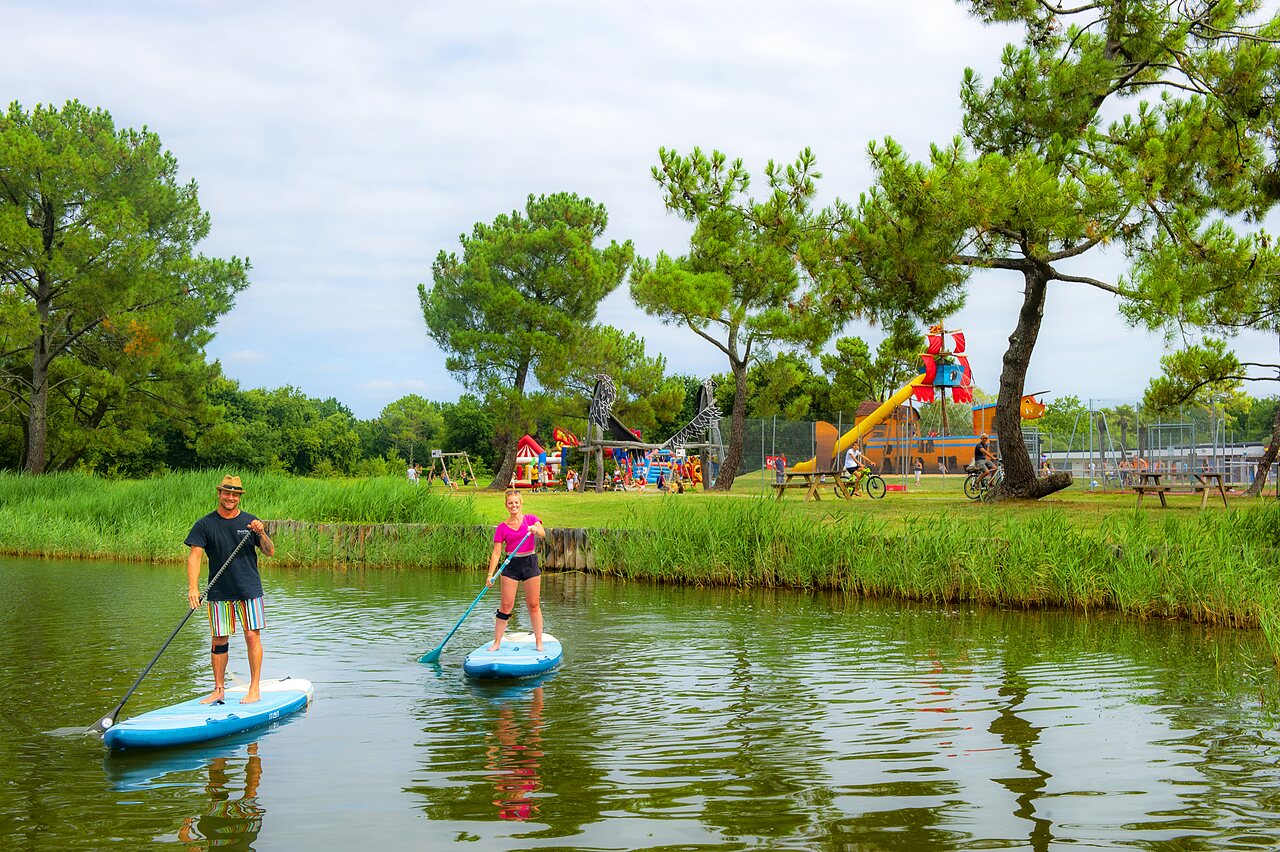 Paddleboarders sur l'eau, aire de jeux enfants au camping CAPFUN Roumingue � LANTON (33).