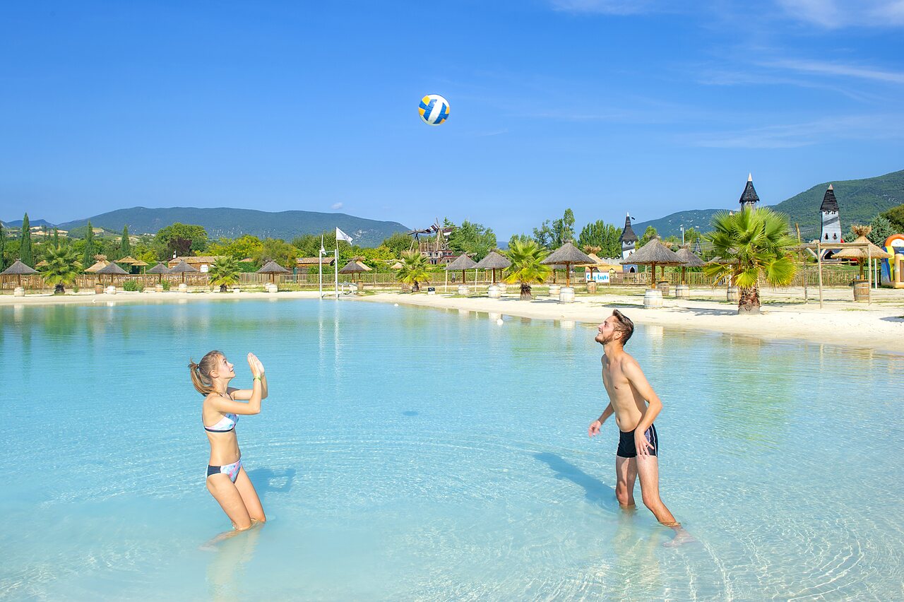 Couple jouant volleyball piscine lagon camping CAPFUN Sagittaire VINSOBRES (26).