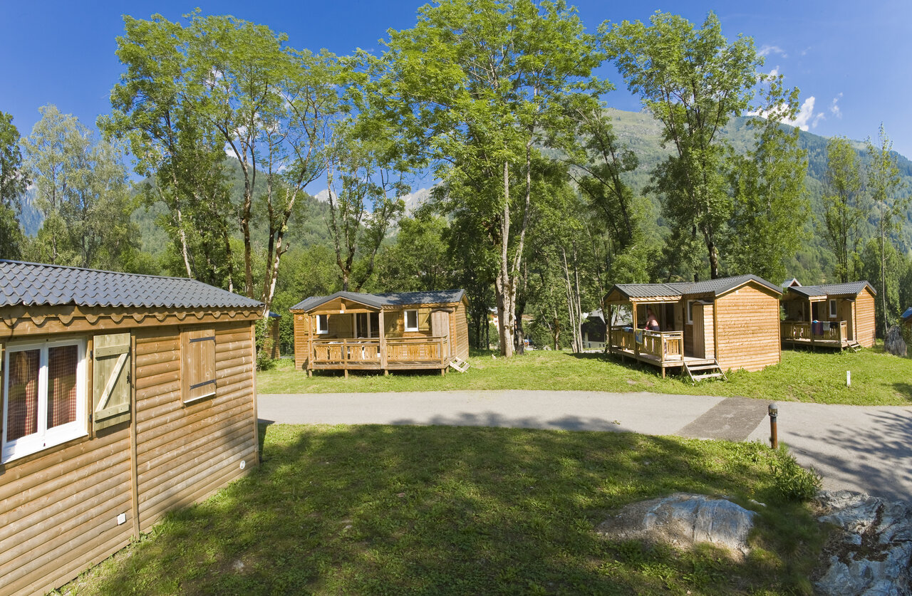 Mobil-homes en bois avec terrasses, entour�s d'arbres au camping CAPFUN Saint Colomban.