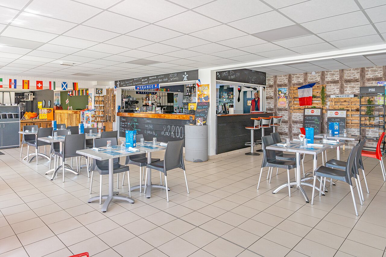 Bar et espace restaurant int�rieur avec tables au camping CAPFUN Saint Laurent � LA FORET FOUESNANT (29).