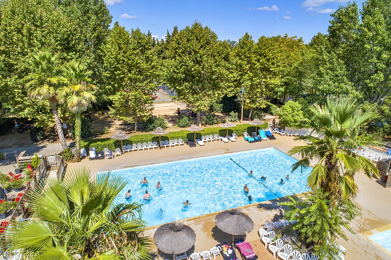 Piscine ext�rieure avec baigneurs et transats, vue a�rienne au camping CAPFUN Soubeyranne � REMOULINS (30).