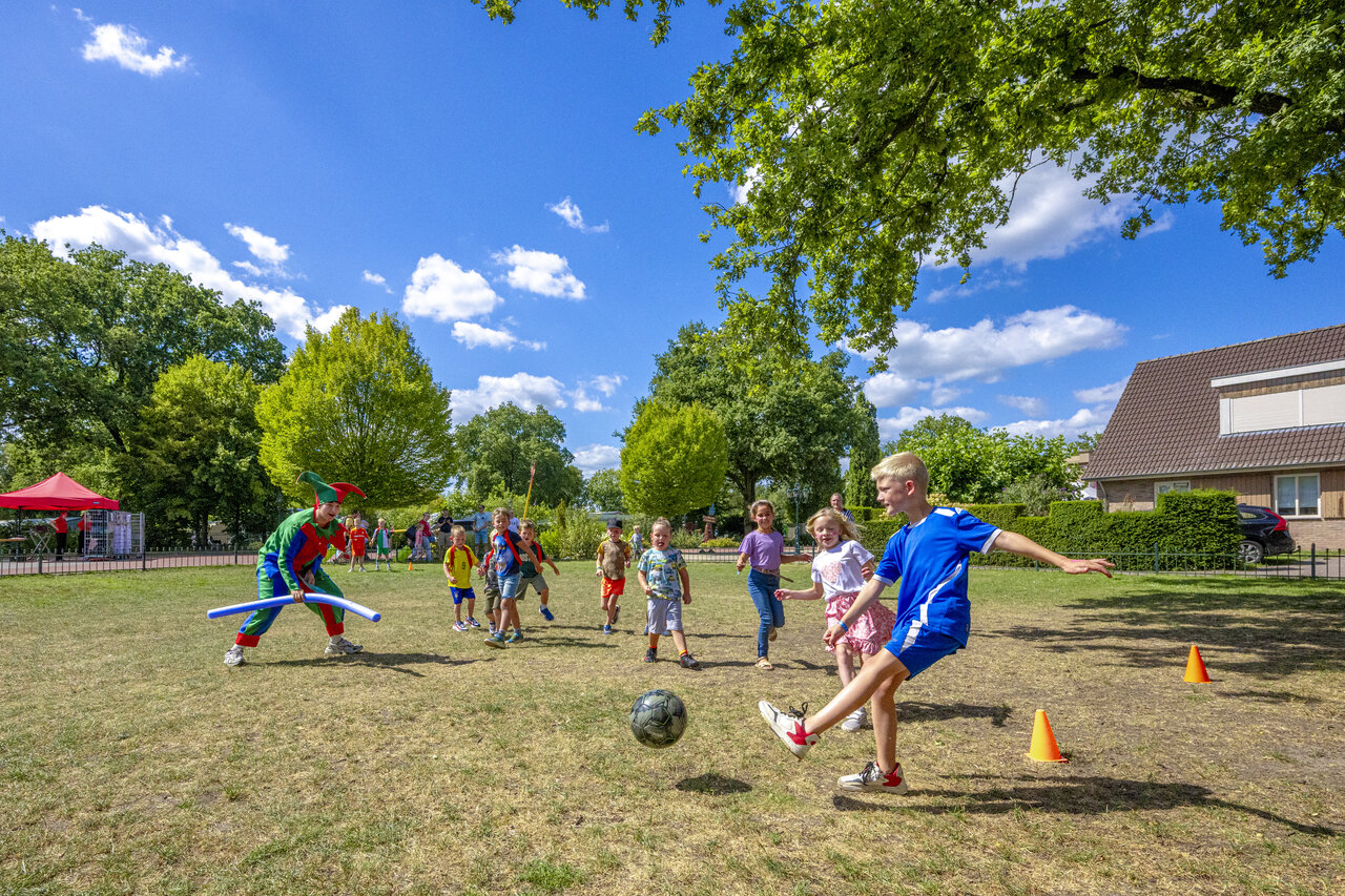 Enfants jouant au football avec animateur d�guis� au camping CAPFUN De Sprookjescamping � Rheeze.
