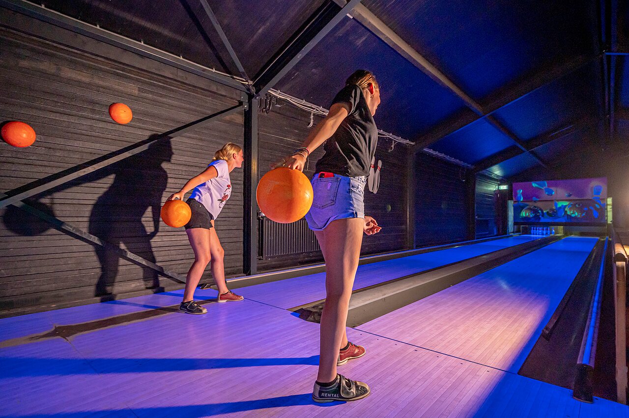 Jeunes s'amusant au bowling sur pistes lumineuses au camping CAPFUN Vakantiepark het Stoetenslagh � Rheezerveen.
