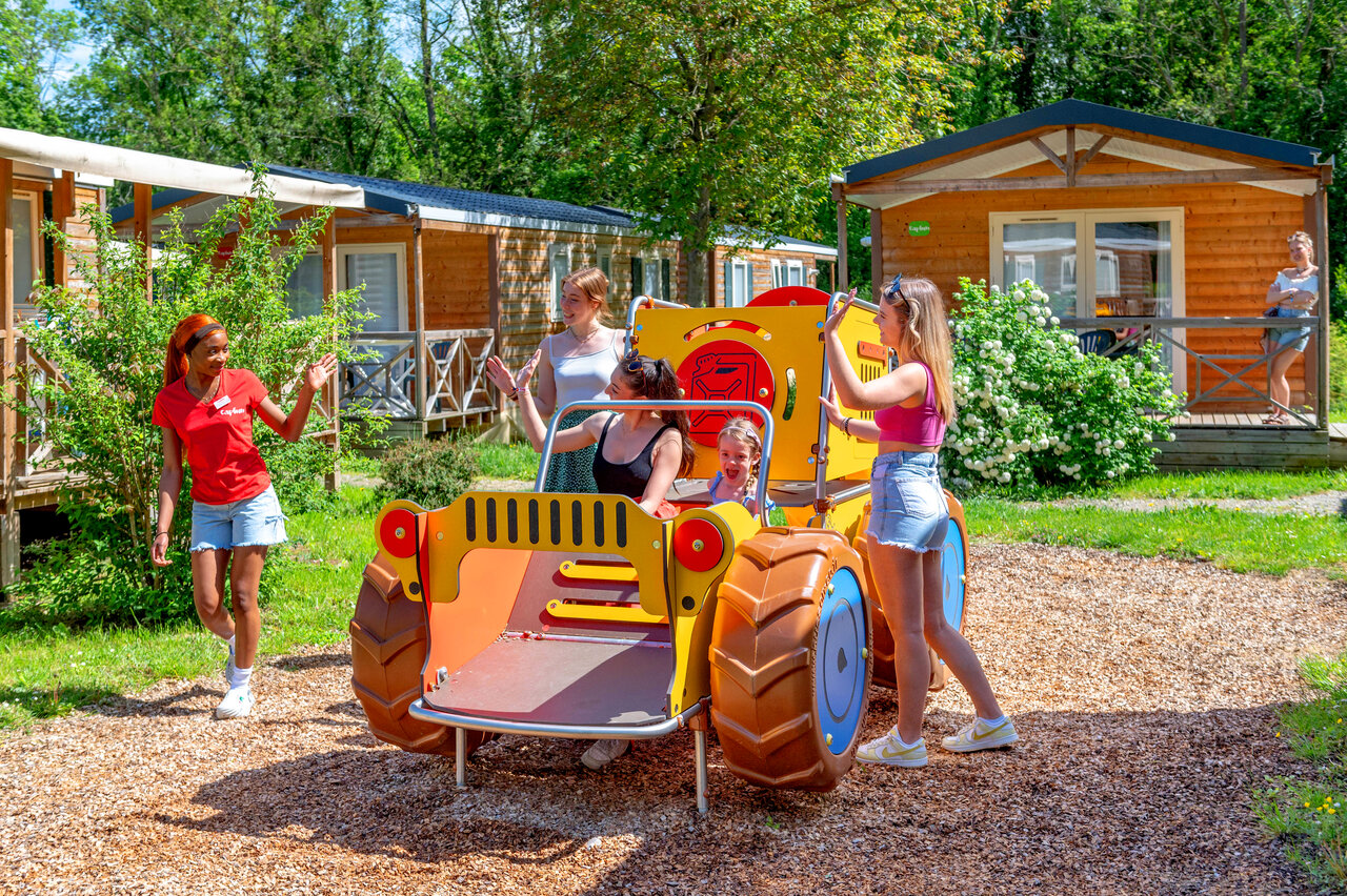 Enfants et animateur sur aire de jeux tracteur au CAPFUN Suzel Sainte-Croix-en-Plaine (68).