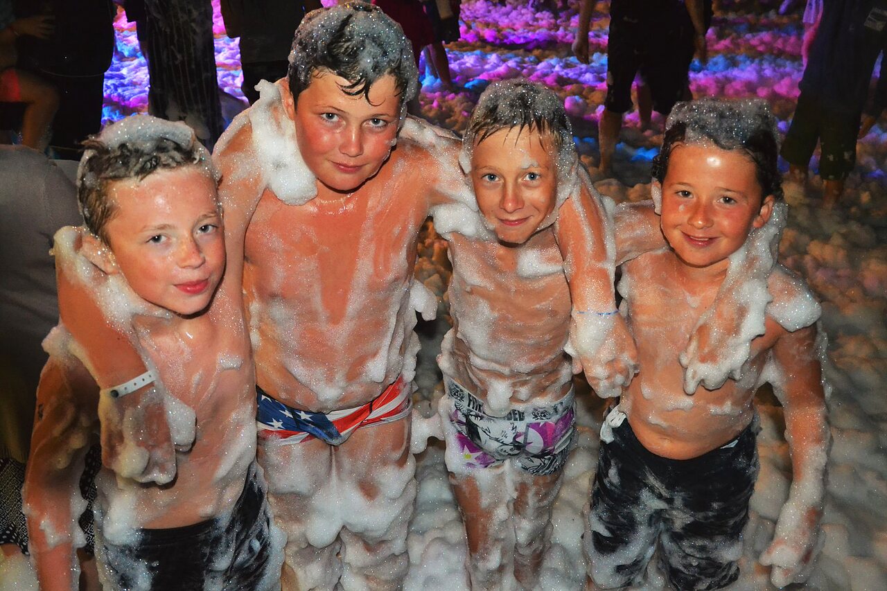 Enfants souriants profitant d'une f�te mousse anim�e au camping CAPFUN Talaris Vacances � Lacanau (33).