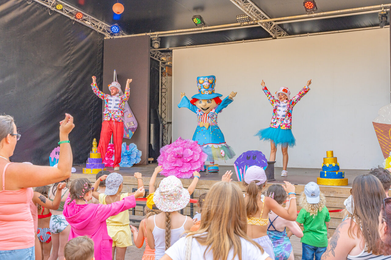 Spectacle d'animation avec mascotte et enfants participants au camping CAPFUN Temps Libre � BOUGE CHAMBALUD (38).