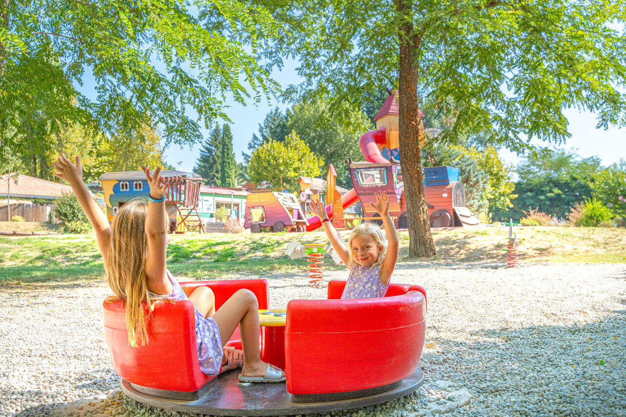 Enfants sur man�ge, aire de jeux au camping CAPFUN Temps Libre � BOUGE CHAMBALUD (38).