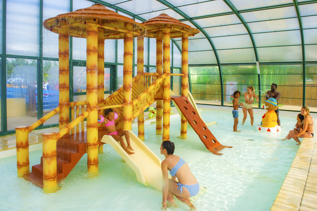 Espace aquatique couvert avec jeux d'eau et toboggans au camping CAPFUN Celeste � Breuillet (17).