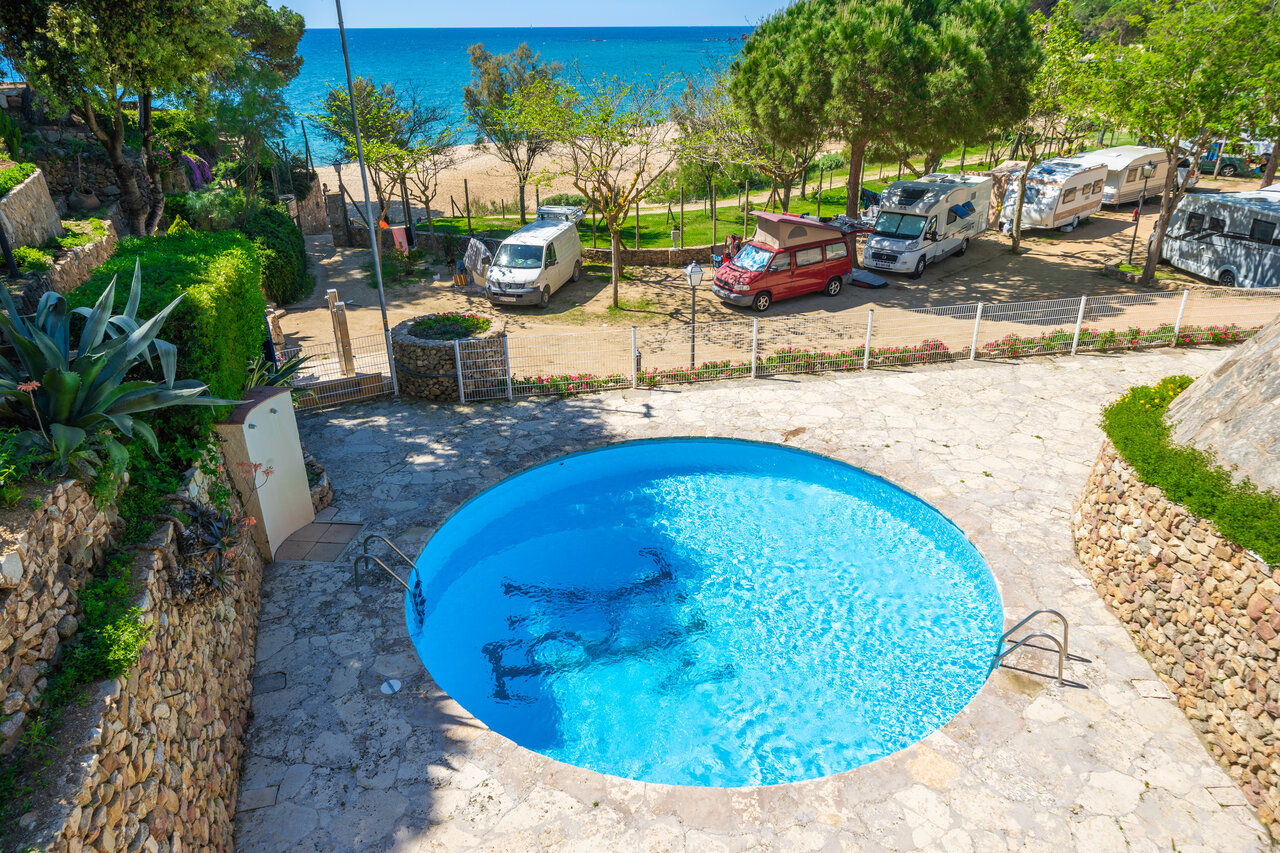 Piscine ronde, plage de sable et emplacements caravanes au camping CAPFUN Treumal � Platja d'Aro (17).