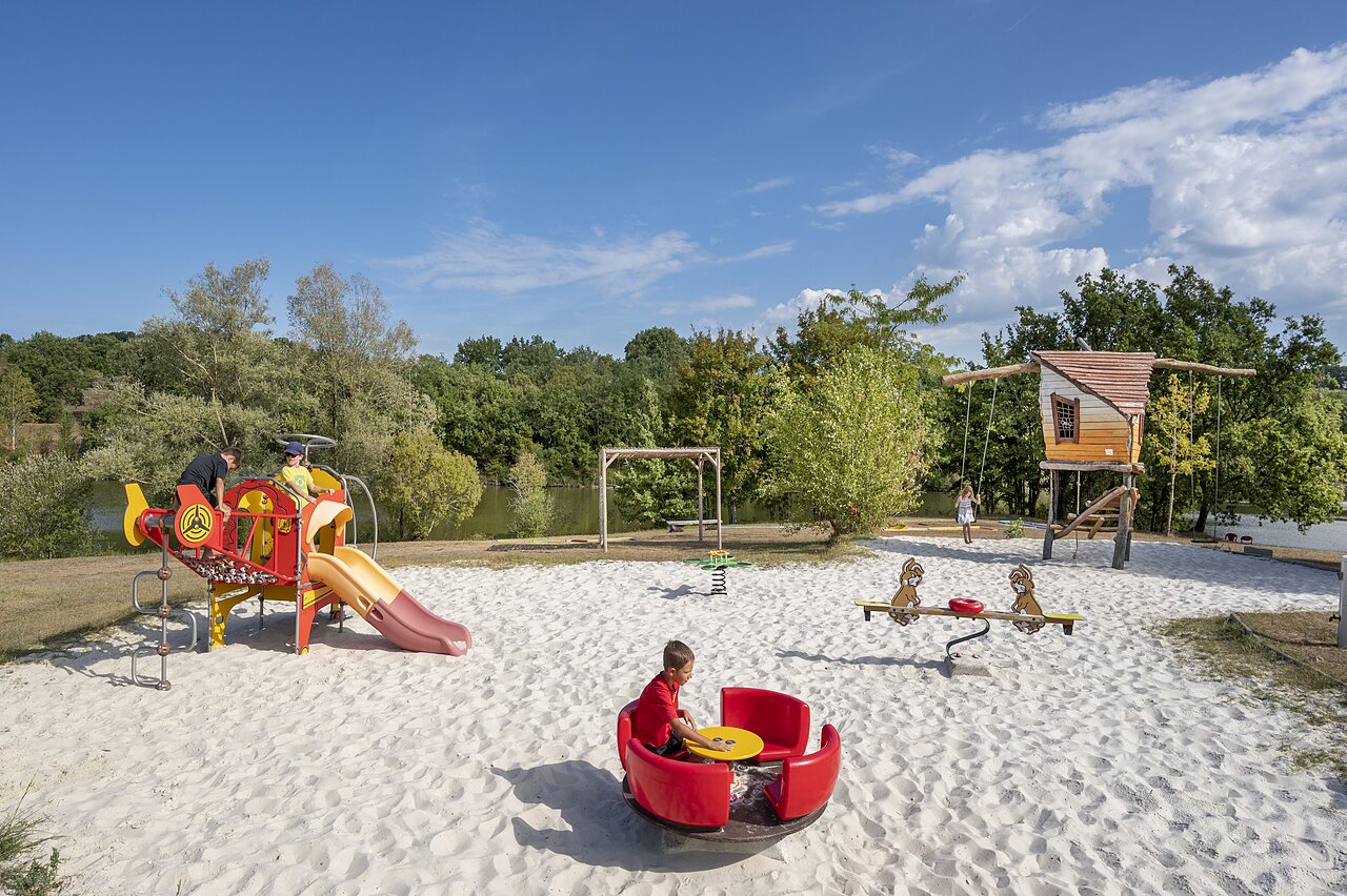 Aire de jeux avec toboggan, balan�oires et carrousel au camping CAPFUN Ullule � Tournon d'Agenais (47).