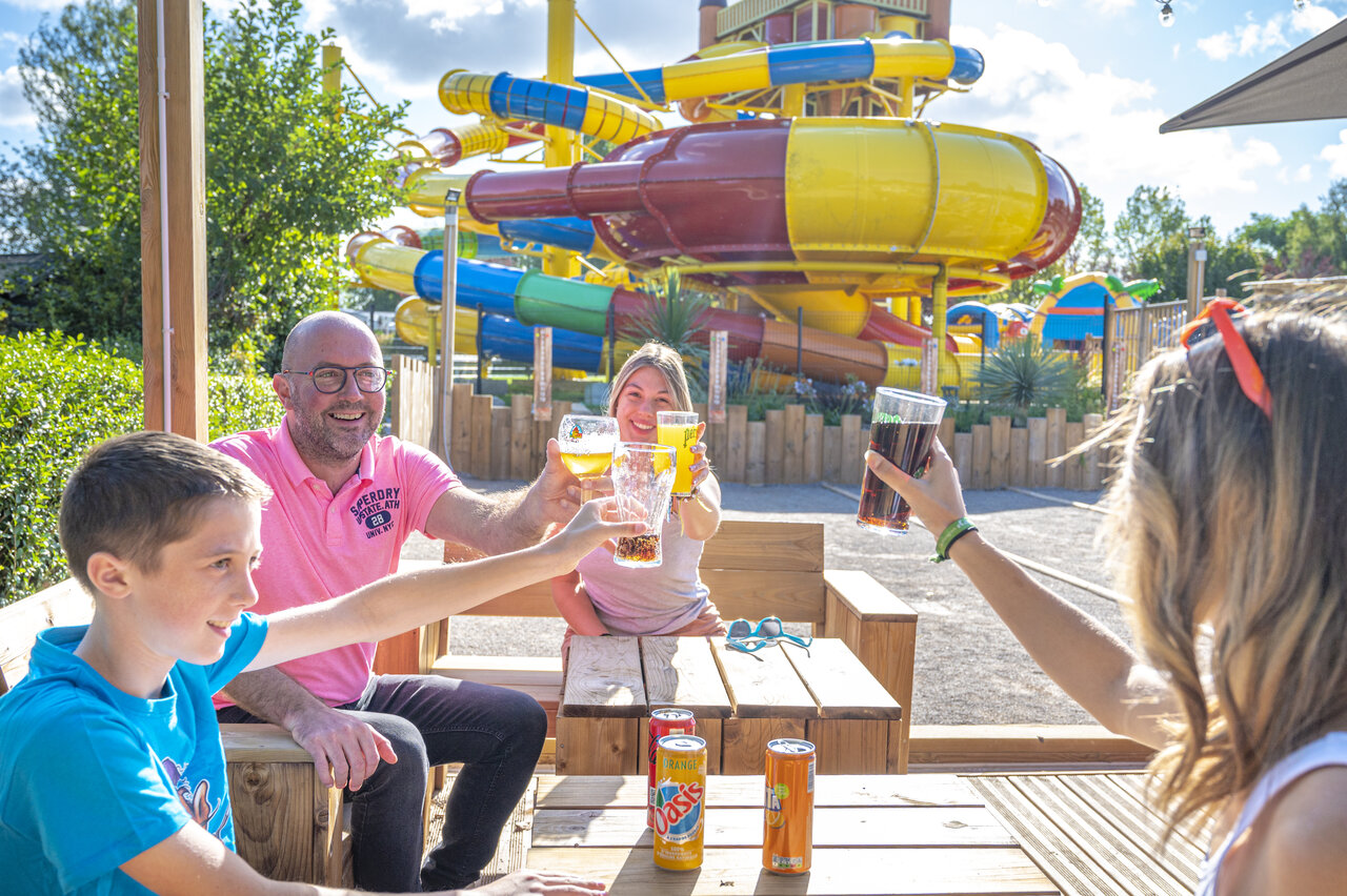 Famille trinquant au bar, toboggans aquatiques au camping CAPFUN Val d'Authie (80).