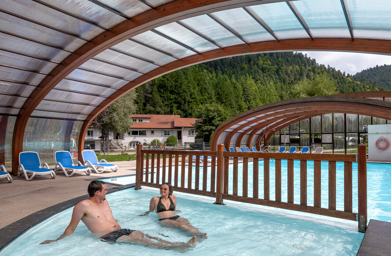 Overdekt zwembad, spa met stel op camping CLICOCHIC Verte Vall�e XONRUPT LONGEMER.