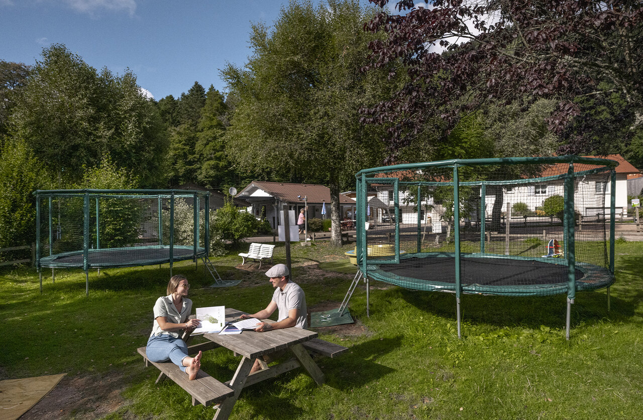 Twee trampolines en stel aan picknicktafel op camping CLICOCHIC Verte Vall�e in XONRUPT LONGEMER.