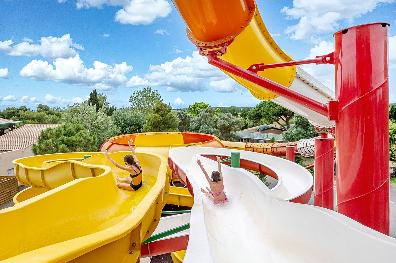 Deux enfants sur des toboggans aquatiques color�s au camping CAPFUN Vignes d'Or � Serignan.