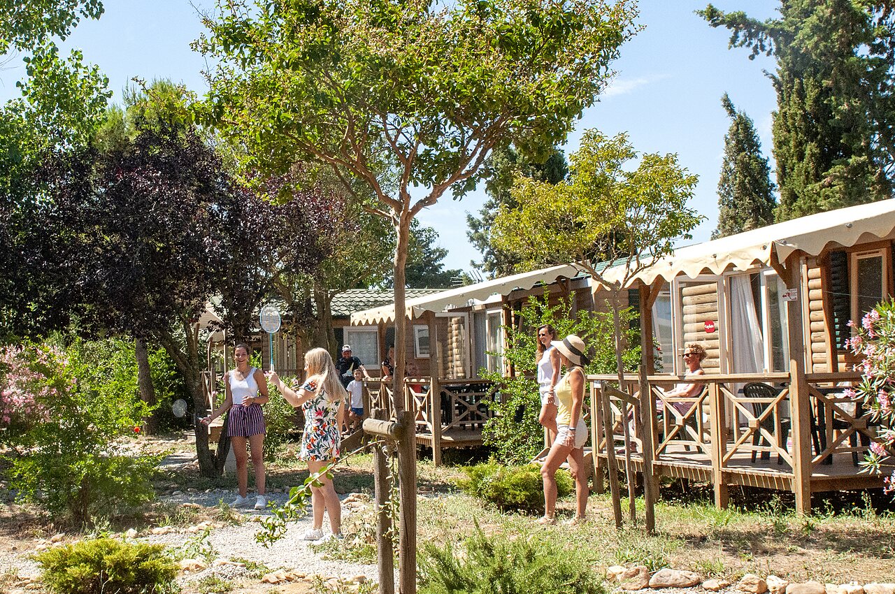 Famille jouant au badminton devant des Mobil-homes au camping CAPFUN Vignes d'Or � Serignan.