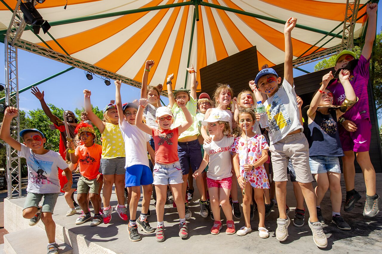 Enfants joyeux et maquill�s participant � une animation sur sc�ne au camping CAPFUN Vignes d'Or � Serignan.