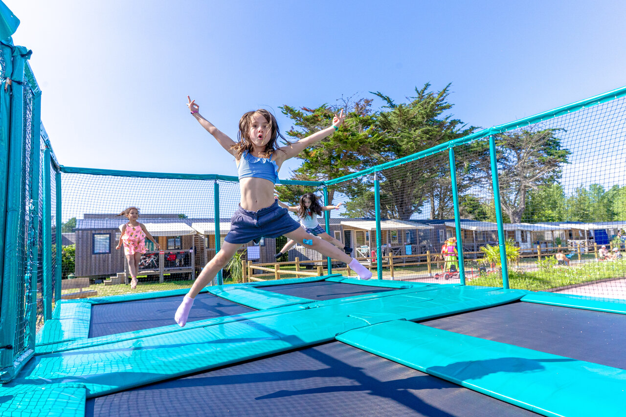 Enfants sautant sur les trampolines, Mobil-homes en arri�re-plan au camping CAPFUN Vikings � Saint Jean de la Rivi�re (50).