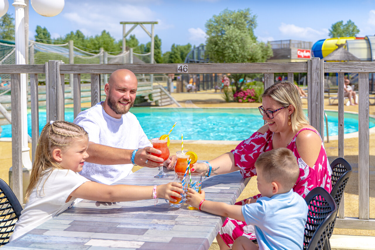 Famille avec boissons au bord de la piscine du camping CAPFUN Vikings � Saint Jean de la Rivi�re (50).