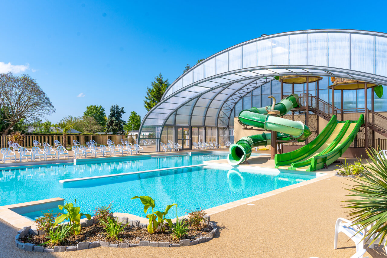 Swimming pool, slides and roof at CAPFUN Le Village Parisien campsite in VARREDDES.