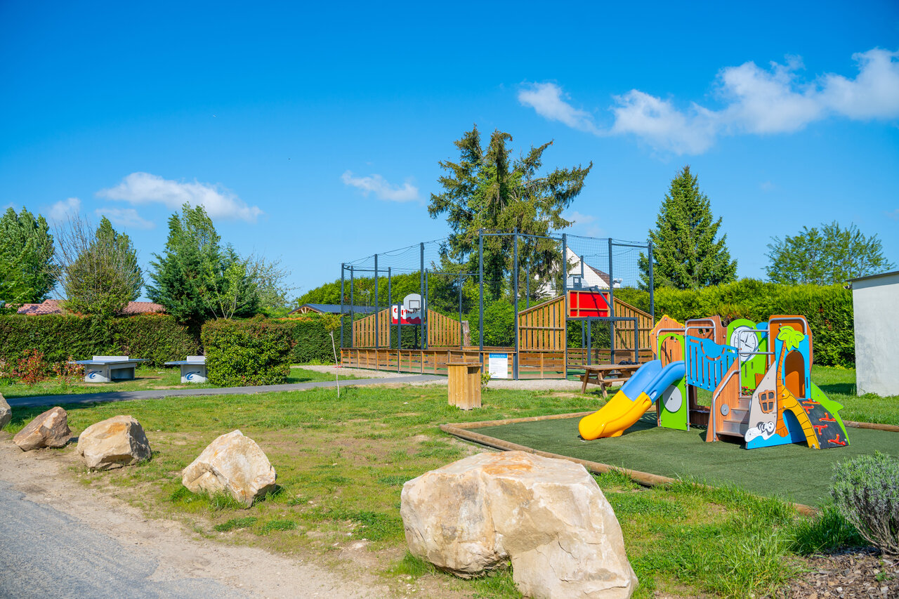 Colorful playground, multisport court, and ping-pong tables at CAPFUN Le Village Parisien campsite in VARREDDES (77).