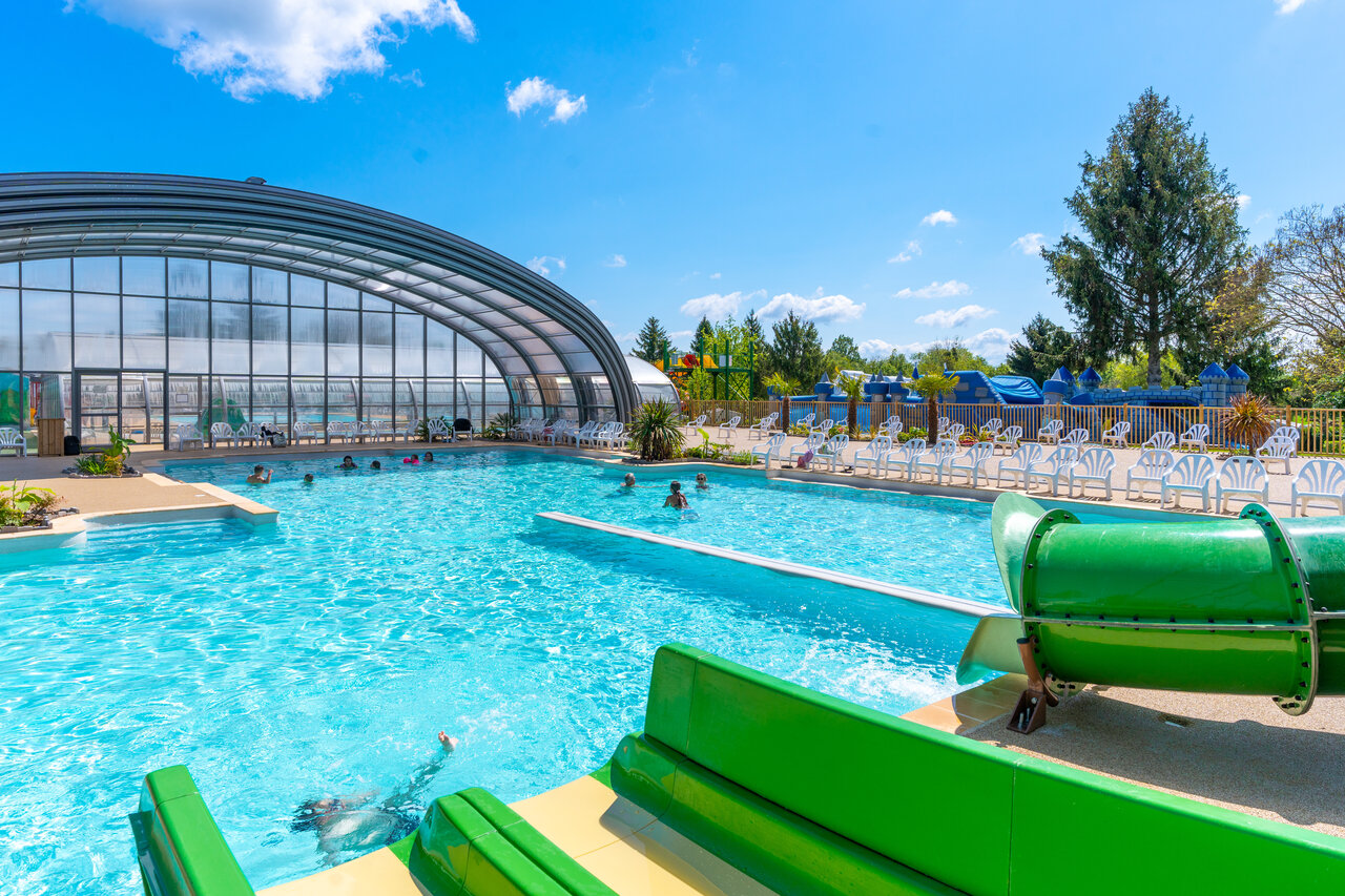 Outdoor and indoor swimming pool with slides at CAPFUN Le Village Parisien campsite in VARREDDES (77).