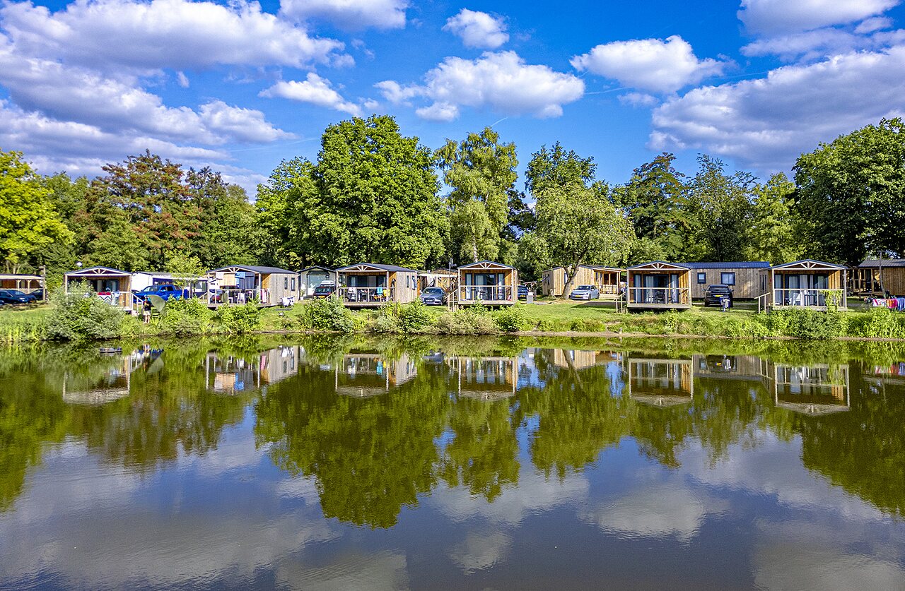 Mobil-homes en bois au bord d'un lac, nature verdoyante, au camping CAPFUN Vlinderloo � Enschede.
