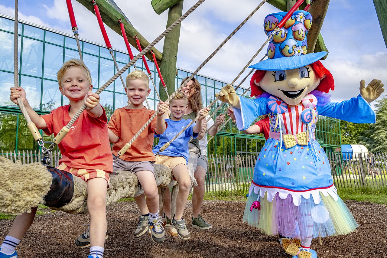 Enfants et mascotte sur une balan�oire g�ante au camping CAPFUN Vlinderloo � Enschede.