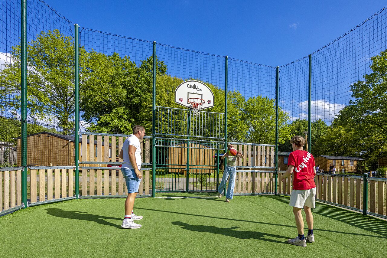 Terrain multisport avec panier de basket et joueurs au camping CAPFUN Vlinderloo � Enschede.