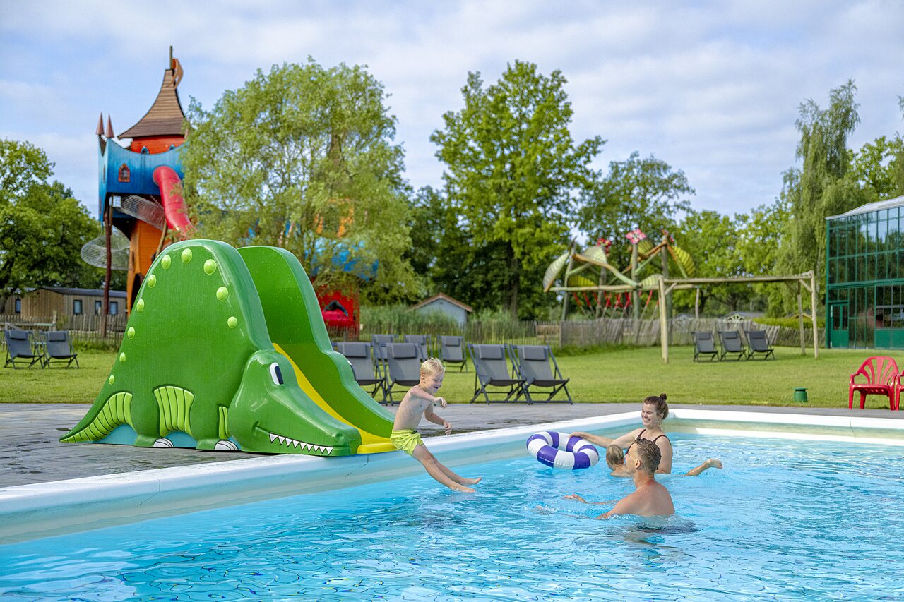 Piscine ext�rieure avec toboggan crocodile et enfants au camping CAPFUN Vlinderloo � Enschede.